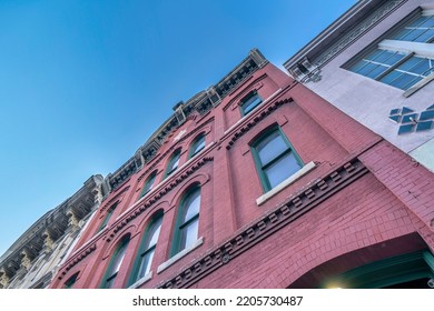 San Francisco, California- Low Angle View Of Adjacent Residential Buildings Against The Blue Sky. View From Below Of A Victorian Style House With Red Bricks And Single-hung Windows In The Middle.