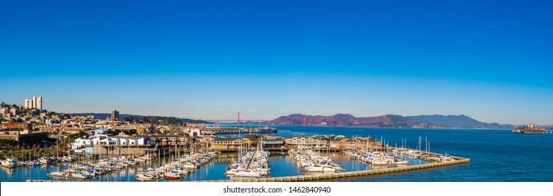 San Francisco, California - October 05 2017: San Francisco, California. Panorama cityscape skyline, Golden Gate Bridge, Alcatraz, buildings. Yachts boats berthed by waterfront pier in west coast city.