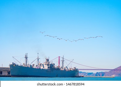 San Francisco, California - October 05 2017: San Francisco, California. Birds In A Row Over SS Jeremiah Obrien Warship And Golden Gate Bridge In The City. Summer Day In The Bay Area On West Coast.