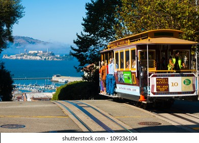 San Francisco, California - September 21, 2011: Powell Hyde cable car, an iconic tourist attraction, descending a steep hill peak overlooking Alcatraz prison island and the bay
