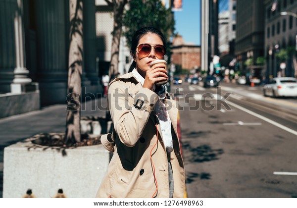 san francisco city commute waiting taxi cab.\
Asian businesswoman walking to work in the morning commuting\
drinking coffee cup on street with cars in the background banner.\
People commuters lifestyle.