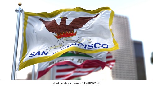 San Francisco city flag waving in the wind with California state and United States national flags blurred in background. San Francisco municipal flag