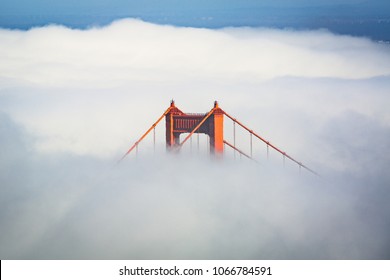 San Francisco Golden Gate Bridge poking through thick fog during the day