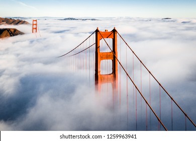 San Francisco Golden Gate Bridge Covered in Fog on Clear Day - Powered by Shutterstock