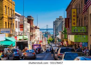 San Francisco - September 20, 2015: Downtown City Life In A Busy Street Of Chinatown San Francisco. View With Many People, Shops And Cars - Lookout To The Oakland Bay Bridge.