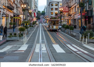 SAN FRANCISCO, USA - DECEMBER 10, 2019, a classic view of historic traditional cable cars traveling through California's famous streets in the morning light at dawn in San Francisco, USA