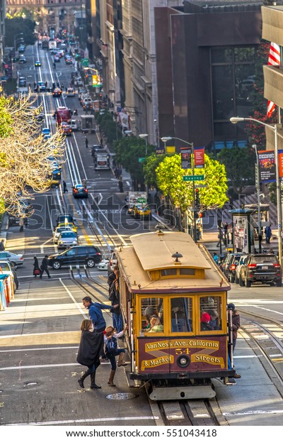 SAN FRANCISCO, USA - DECEMBER 16: Passengers enjoy\
a ride in a cable car on Dec 16, 2013 in San Francisco. It is the\
oldest mechanical public transport in San Francisco which is in\
service since 1873.