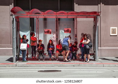 SAN FRANCISCO, USA - JUNE 20, 2012:  People Wait In A Booth At A Busstop In Front Of Old Chronicle Building For The Next Bus In Midday Heat.