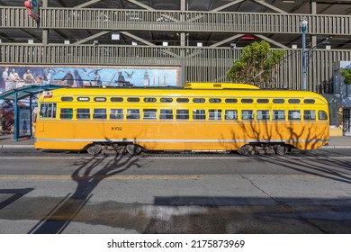San Francisco, USA - June 6, 2022:  yellow vintage bus operates from Fisherman's wharf to market street downtown San Francisco. Tourists enjoy traveling with this electric vintage bus.