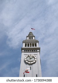 San Francisco's Waterfront Landmark - The Ferry Building Clock Tower With Plane Flying Above.