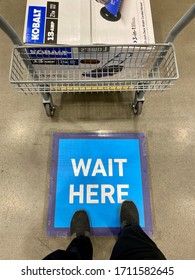 San Jose, CA - April 15, 2020: Closeup Of Shopping Cart With New Lawn Mower Inside With Man Standing On The 