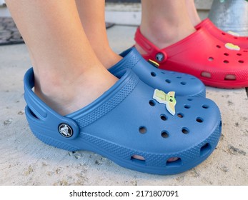 San Jose, CA - June 24, 2022: Closeup Of Red And Blue Crocs Shoes Being Worn By Two Kids. 