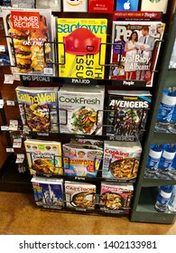 San Jose, CA - May 18, 2019: A rack full of magazines and other print periodicals inside a store near the checkout lane.