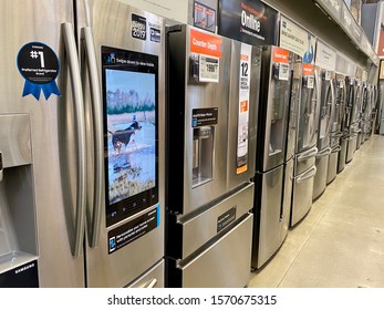 San Jose, CA - November 22, 2019: Row of new stainless steel double door refrigerator units inside Home Depot store.