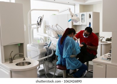 San Jose / Costa Rica; July 1, 2016; Dentist Mario Garita (R) Works On A Dental Patient With An Assistant In Costa Rica. His Business Is Called The Dental Experience And Practices Holistic Dentistry.