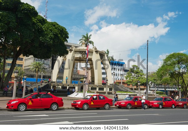 San Jose, Costa\
Rica - June 18, 2012: Red taxi cabs wait in line at the Central\
Park in San Jose, Costa\
Rica.
