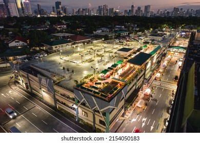 San Juan, Metro Manila, Philippines - May 2022: A Car Park With A Bazaar At The Roof Deck. Evening Scene With The Metro Manila Cityscape In The Horizon.