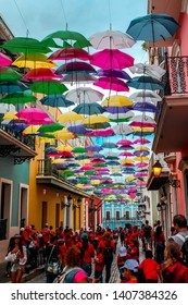 San Juan, Puerto Rico - February 14, 2019: Bright Umbrellas Handing Above The Street In Old San Juan Puerto Rico. People Enjoying Bright Umbrellas In Old San Juan Puerto Rico.