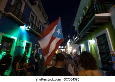 SAN JUAN, PUERTO RICO - JAN 16TH, 2016 - Revelers Party In The Streets Carrying The Flag Of Puerto Rico During The San Sebastian Street Festival In Old Town San Juan. 