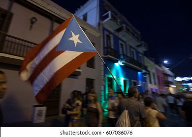 SAN JUAN, PUERTO RICO - JAN 16TH, 2016 - Revelers Party In The Streets Carrying The Flag Of Puerto Rico During The San Sebastian Street Festival In Old Town San Juan. 