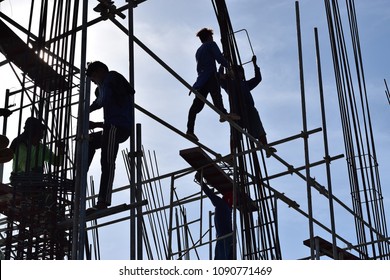 San Pablo City, Laguna, Philippines - May 4, 2018: Filipino Construction steel workers assembling steel bars on high-rise building wearing improper protective suits and safety shoes. silhouettes