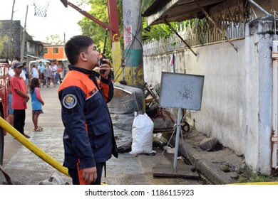 San Pablo City, Laguna, Philippines - September 22, 2018: Fire Officer Beside Fire Truck Holding Radio During House Fire That Gutted Interior Shanty Houses