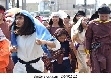 San Pablo City, Laguna, Philippines - April 19, 2019: Mob of furious people persecuting Jesus Christ gaher on plaza cheering, ridicule, street drama, community celebrates Good Friday.