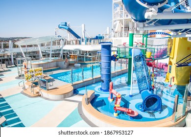 San Pedro, California - October 11 2019: Empty Sun Deck Onboard Norwegian (NCL) Joy Cruise Ship With Waterslides And Pools For Adults And Children, Hot Tubs, And Lounge Chairs For Sunbathing.