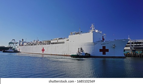 San Pedro, California USA - March 27, 2020: US Navy Hospital Ship Mercy Docks At The Port Of Los Angeles Harbor, Assisted By Tugboats, To Provide Medial Assistance During Covid-19 Coronavirus Pandemic