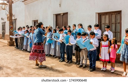 San Pedro De Atacama, Chile - January 12, 2013: Kids Singing Songs Outside A Local Grocery Shop At Caracoles Street In San Pedro De Atacama, Chile.