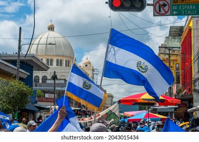 San Salvador, El Salvador - September 15th, 2021: Protesters Hold National Flags And March Near The Cathedral Against The Politics Of Current President Nayib Bukele.