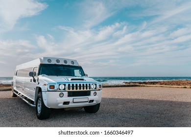 San Vito Lo Capo, Trapani, Italy - February 27 2020: White Hummer Limousine Car Parked Close To The Beach With Sea In The Background, Luxury Car In Sicily