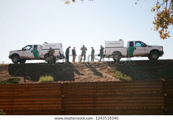 San\
Yasidro, California - 11/26/2018: Border patrol agents discuss\
their next moves and survey the landscape at the US Mexico Border.\
Government and Border agents are all on High\
Alert.