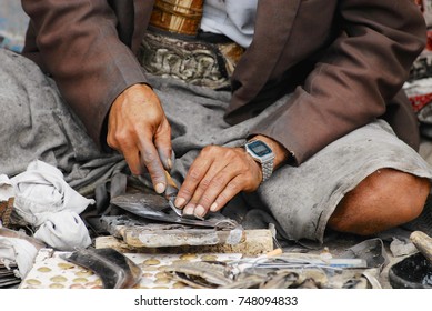 SANAA, YEMEN - SEPTEMBER 18, 2006: Unidentified man sharpens janbiya in Sanaa, Yemen. Janbiya is a traditional dagger and a mandatory attribute of Yemeni men's suit.