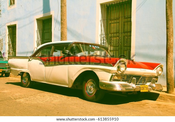 SANCTI SPIRITUS, CUBA - FEBRUARY 6, 2011: Classic\
American car is parked in the street in Sancti Spiritus. Cuba has\
one of lowest vehicle per capita rates in the world (38 per 1000\
citizens in 2008).