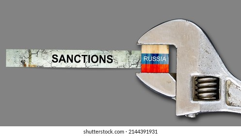Sanctions. Flag of Russia on a wooden block, clamped with a wrench. Isolated on a gray background. Sanctions. Country isolation. economic blockade. Economy. Politics. Conflict. - Shutterstock ID 2144391931