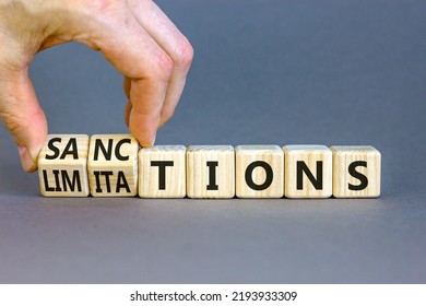 Sanctions Or Limitations Symbol. Businessman Turns Cubes, Changes The Word Sanctions To Limitations. Beautiful Grey Table, Grey Background, Copy Space. Business, Sanction Or Limitation Concept.