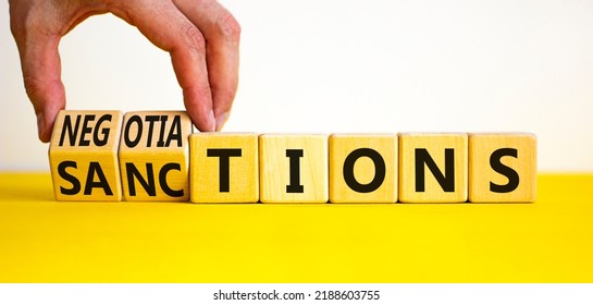 Sanctions Or Negotiations Symbol. Businessman Turns Cubes, Changes The Word Sanctions To Negotiations. Beautiful Yellow Table, White Background, Copy Space. Business, Sanction Or Negotiation Concept.