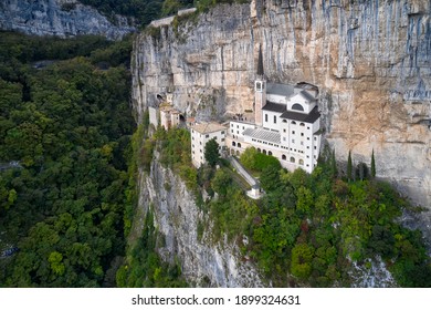 The sanctuary is high in the mountains of Italy. The unique Sanctuary Madonna della Corona church was built in the rock. Aerial view of the church on the sheer cliff. Italian church in the Alps.