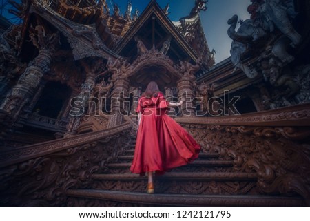 The sanctuary of truth's Entrance with Red dressed lady. Pattaya, Thailand.