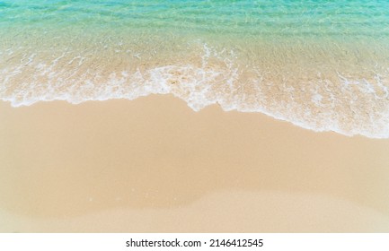 Sand Beach Background with sandy beautiful white foamy and wave from the sea Overhead, beach top view Shore Seaside in Summertime 