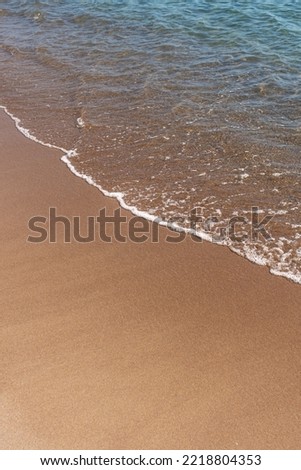 Sand beach and Blue ocean with soft wave form on Sand Texture,Seaside view of Brown Beach sand dune in sunny day Spring, Vertical top view for Summer banner background.