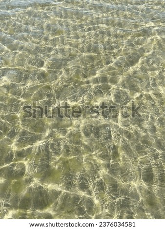Sand beach, sea waves and shallow water