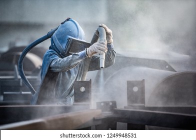 Sand blasting process, Industial worker using sand blasting process preparation cleaning surface on steel before painting in factory workshop. - Shutterstock ID 1249948531