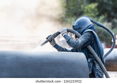 Sand blasting process, Industial worker using sand blasting process preparation cleaning surface on steel before painting in factory workshop. - Shutterstock ID 1261215922