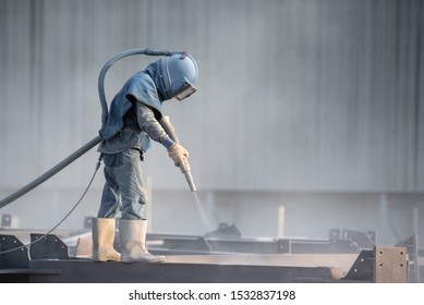 Sand Blasting Process, Industial Worker Using Sand Blasting Process Preparation Cleaning Surface On Steel Before Painting In Factory Workshop.