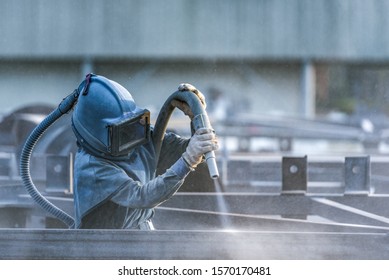 Sand blasting process, Industial worker using sand blasting process preparation cleaning surface on steel before painting in factory workshop. - Shutterstock ID 1570170481