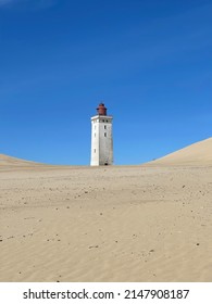 Sand And Blue Sky With The Old Light House In Denmark