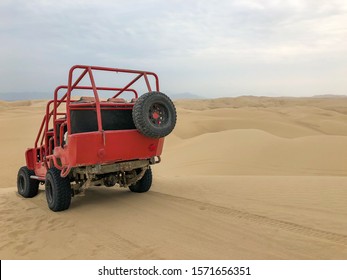 A sand buggy sits on top of a sand dune in the Paracas desert in Peru. 