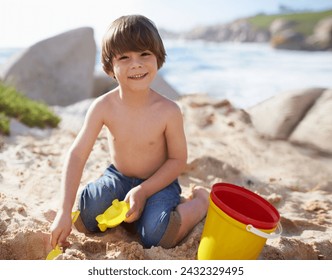 Sand castle, beach and portrait of child with bucket and toys on summer holiday, vacation and relax by ocean. Childhood, building sandcastle and young boy playing for adventure, fun or weekend by sea - Powered by Shutterstock